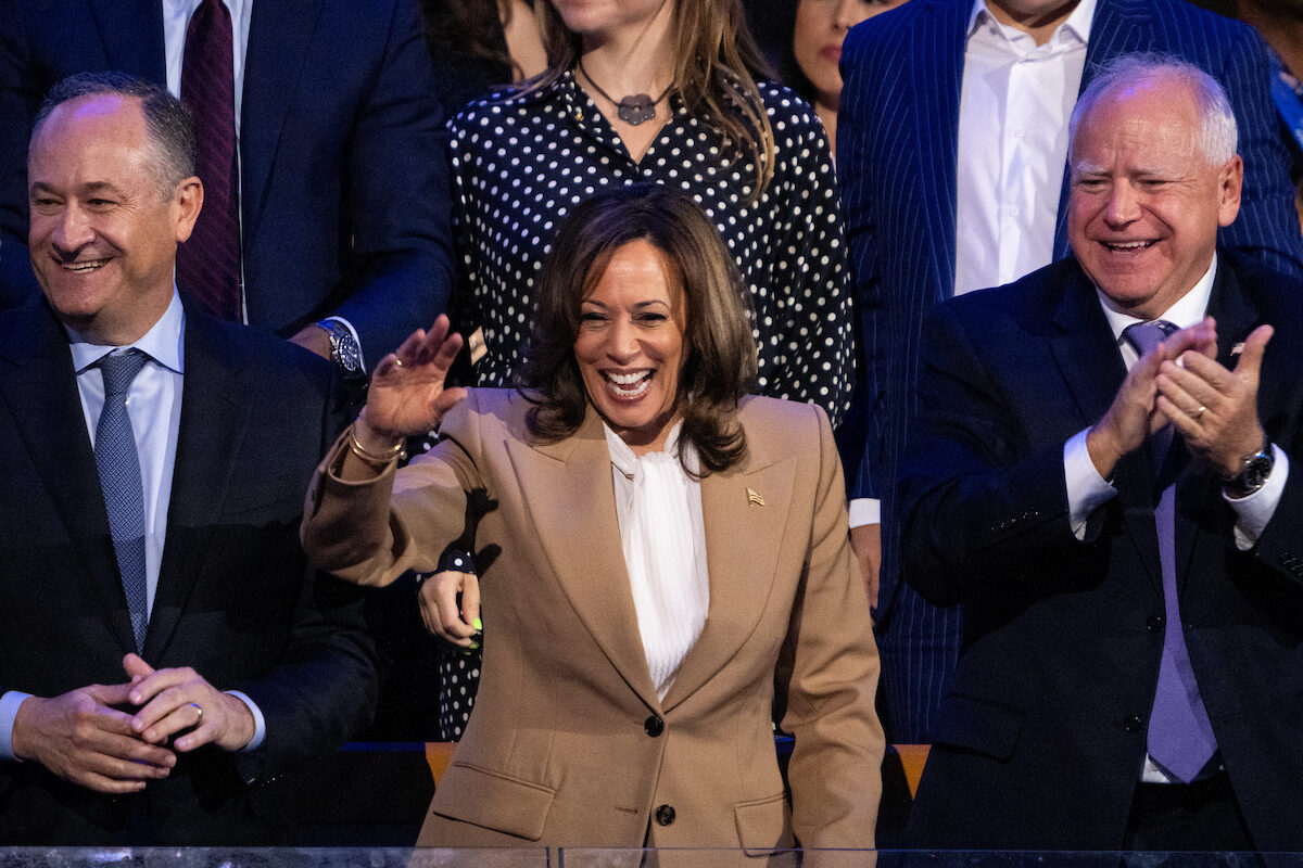 Vice President Kamala Harris waves from her seat flanked by Second gentleman of the United States Doug Emhoff and Minnesota Governor Tim Walz during the 2024 Democratic National Convention at the United Center in Chicago on Monday.