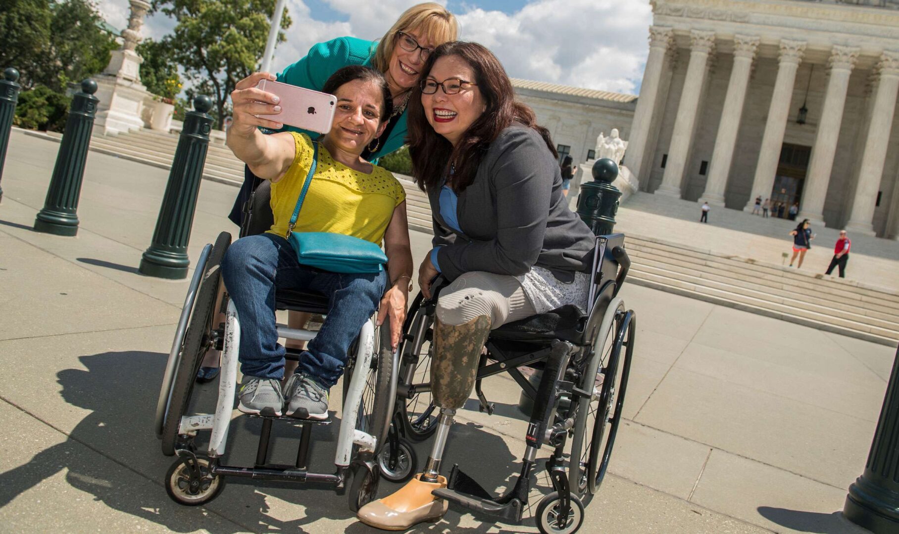 Sens. Tammy Duckworth, D-Ill., right, and Maggie Hassan, D-N.H., take a selfie with Colleen Flanagan of Disability Action for America outside the Supreme Court in July 2017 to mark the anniversary of the Americans with Disabilities Act.