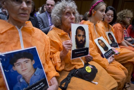 Bev Rice, second from left, and others hold pictures of detainees during a 2013 hearing to examine the closing of the Guantánamo Bay detention facility. (Tom Williams/CQ Roll Call)