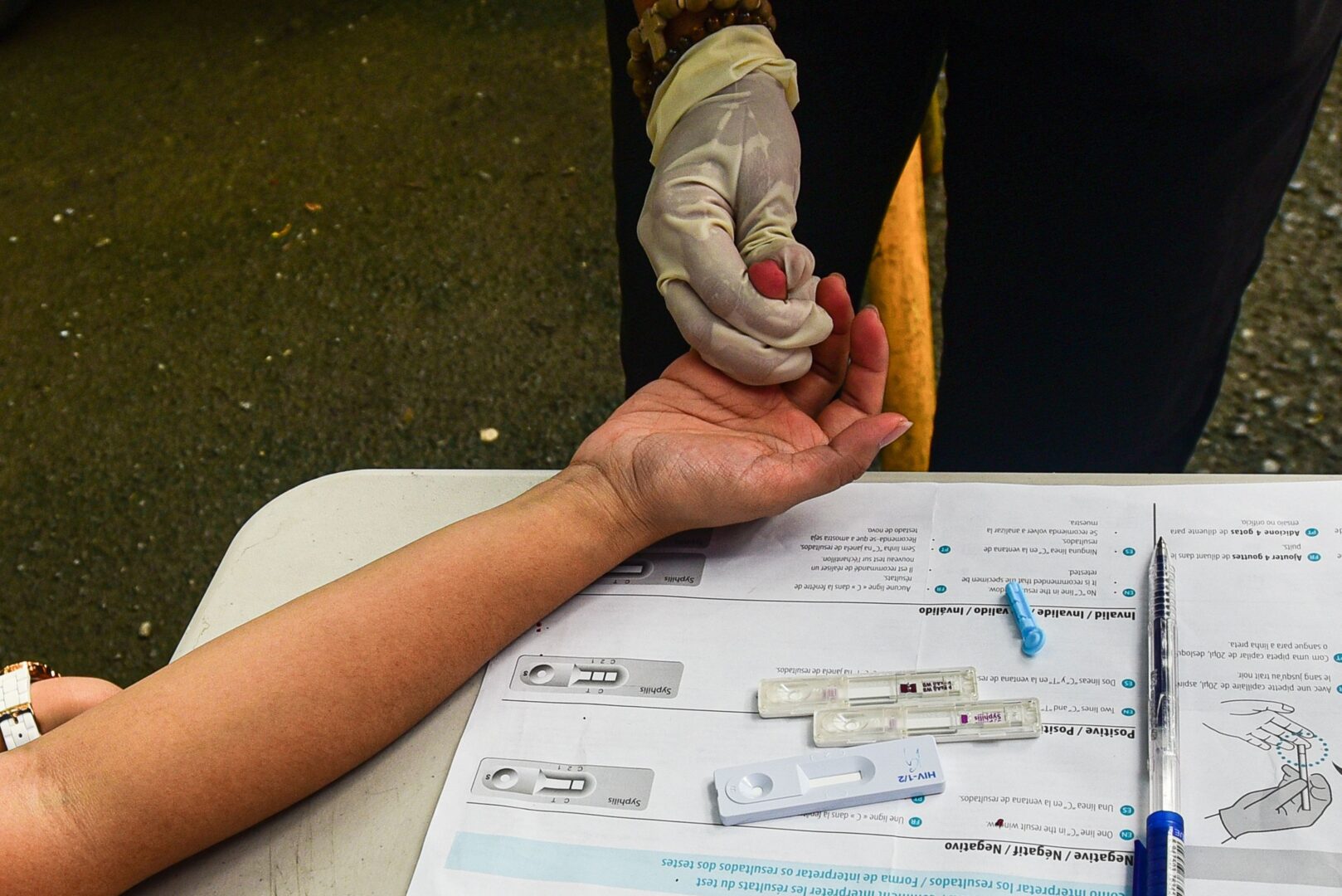 A volunteer medical technologist takes a test blood sample from a student who volunteered for a free HIV testing program at a university in Manila on Sept. 13, 2019.