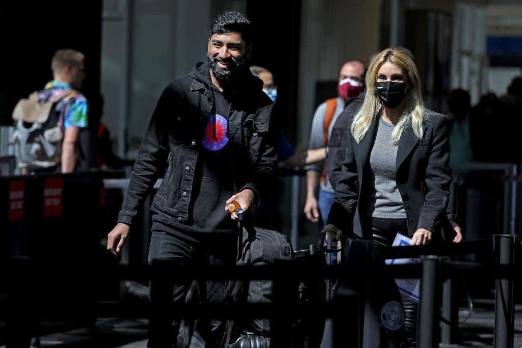 Masked and unmasked passengers make their way through Los Angeles International Airport on Tuesday. The CDC said Wednesday it asked the Justice Department to appeal a federal judge's ruling striking down the mask mandate on airplanes and other public transportation. 