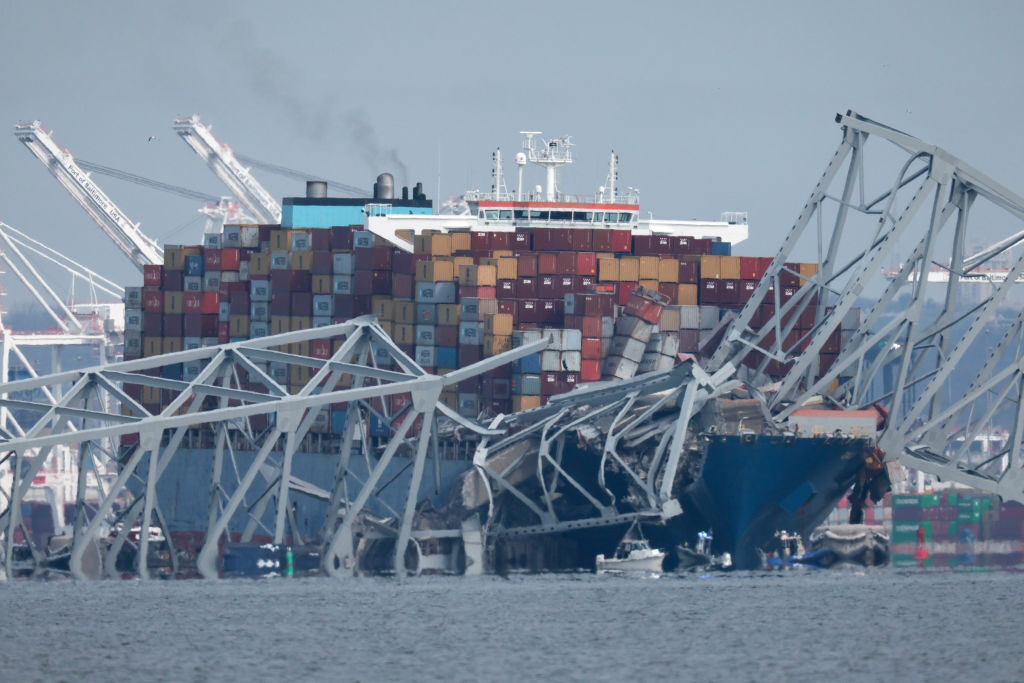 Small boats surround a cargo ship after the ship ran into and collapsed the Francis Scott Key Bridge in Baltimore early Tuesday morning.