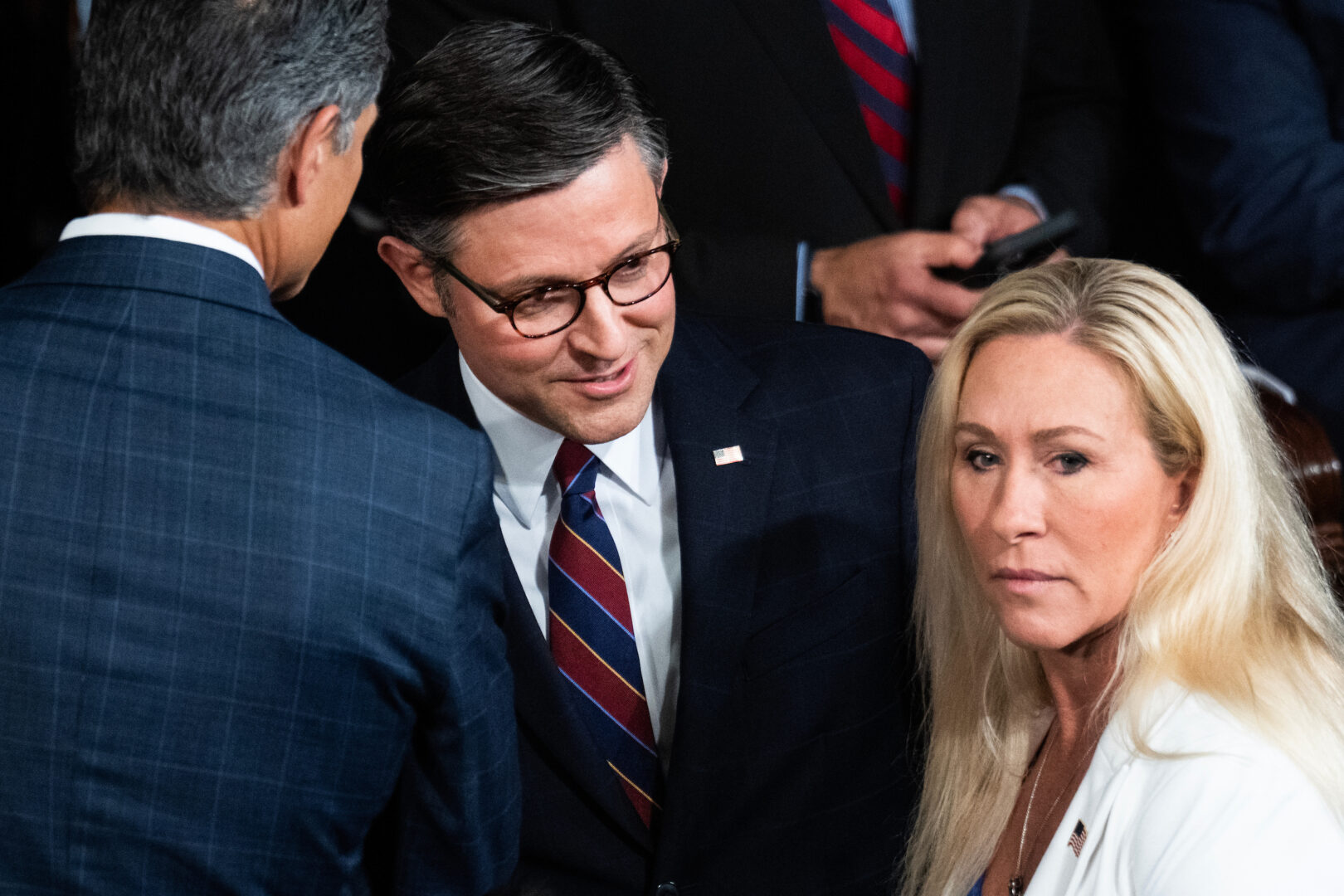 Speaker Mike Johnson, R-La., at center on the House floor Thursday, is trying to find a path for Ukraine and Israel aid as Rep. Marjorie Taylor Greene, R-Ga., at right, threatens to oust him.