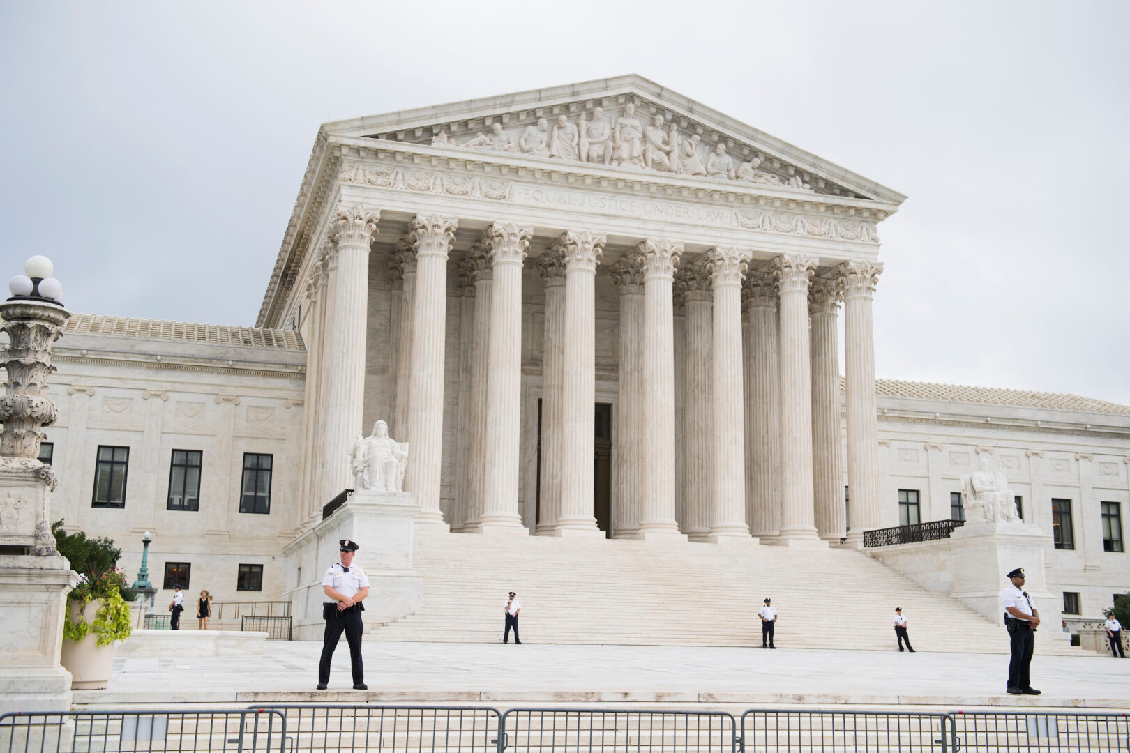 Police stand guard near protesters in front of the Supreme Court in 2018 on the day Justice Brett M. Kavanaugh heard his first oral arguments.